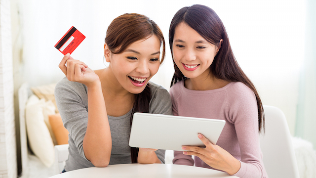 Two Woman shopping online with tablet and credit card